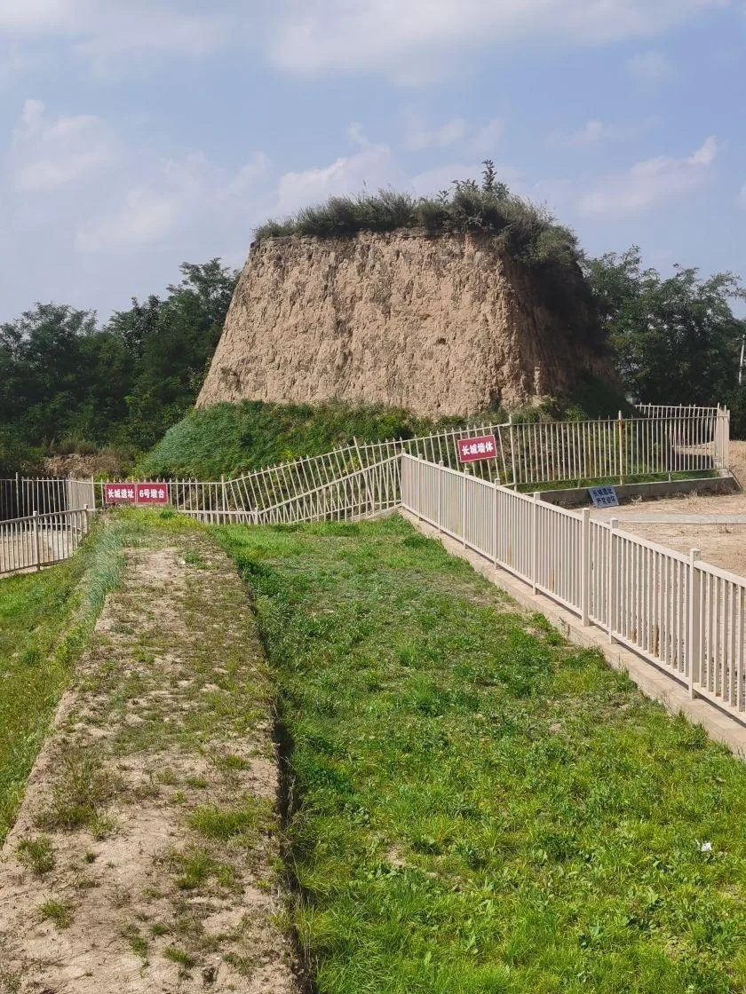 Protected early earth wall heritage site with visitor fencing