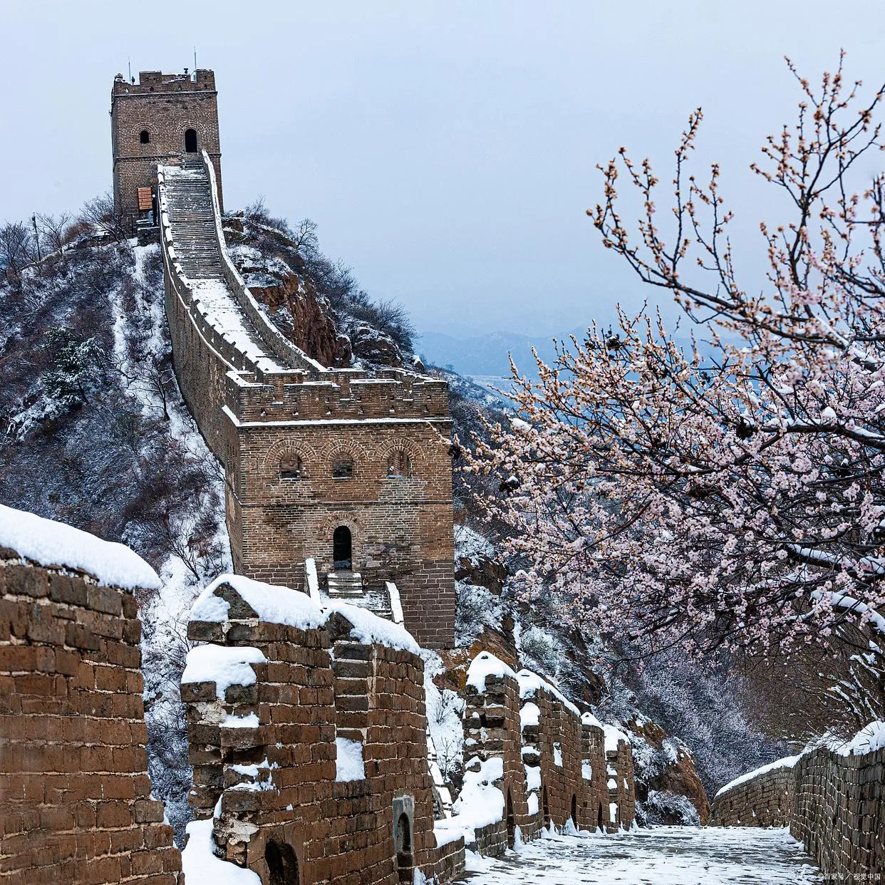 Great Wall watchtower with snow and winter branches