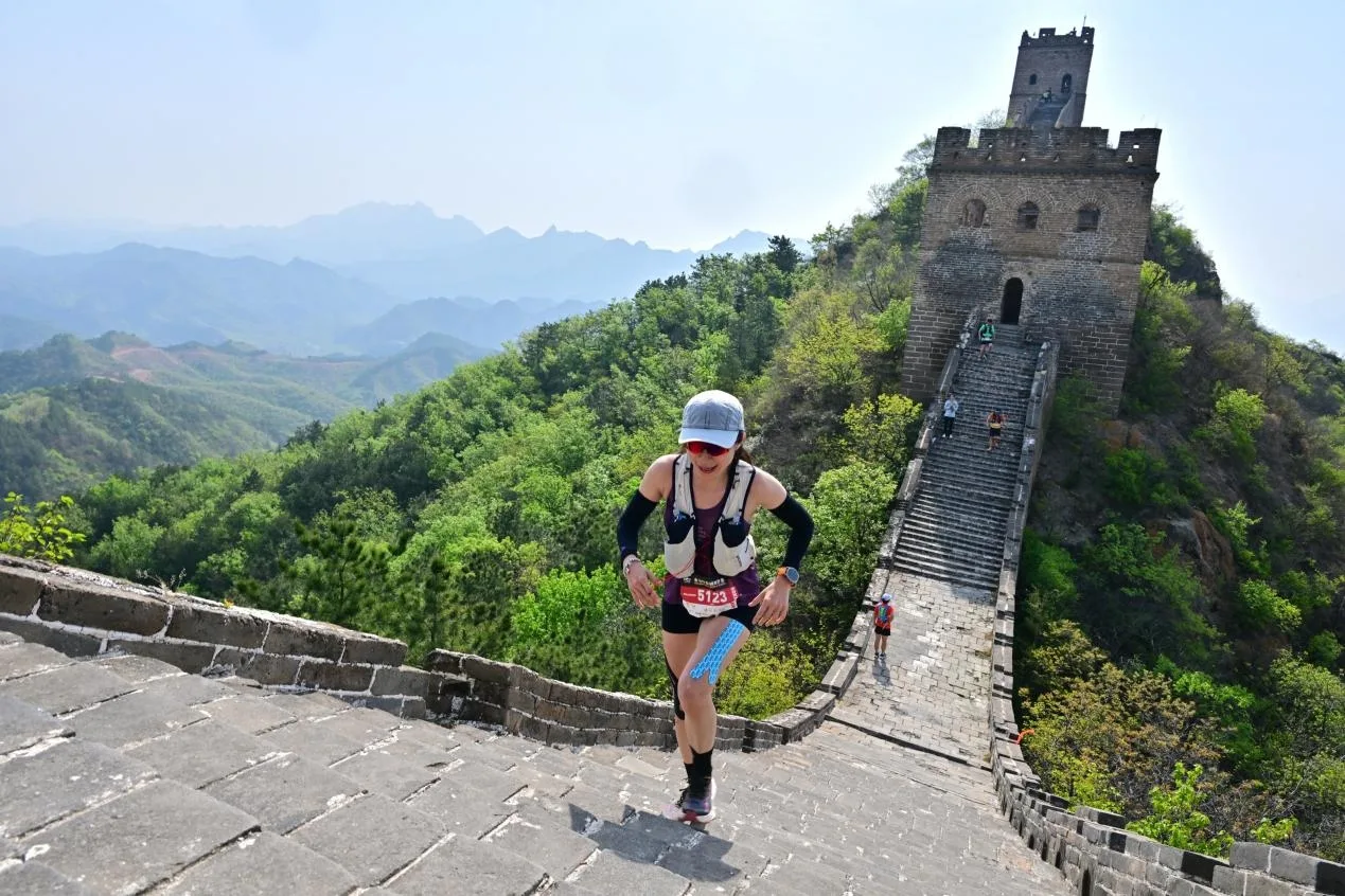 Hiker climbing stone steps on the Gubeikou Jinshanling route