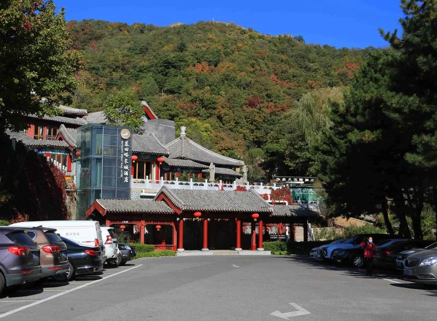 Mutianyu Great Wall visitor arrival area with trees and mountain backdrop