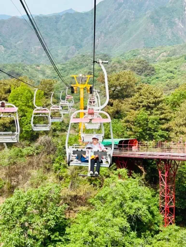 Open chairlift chairs above the Mutianyu Great Wall forest