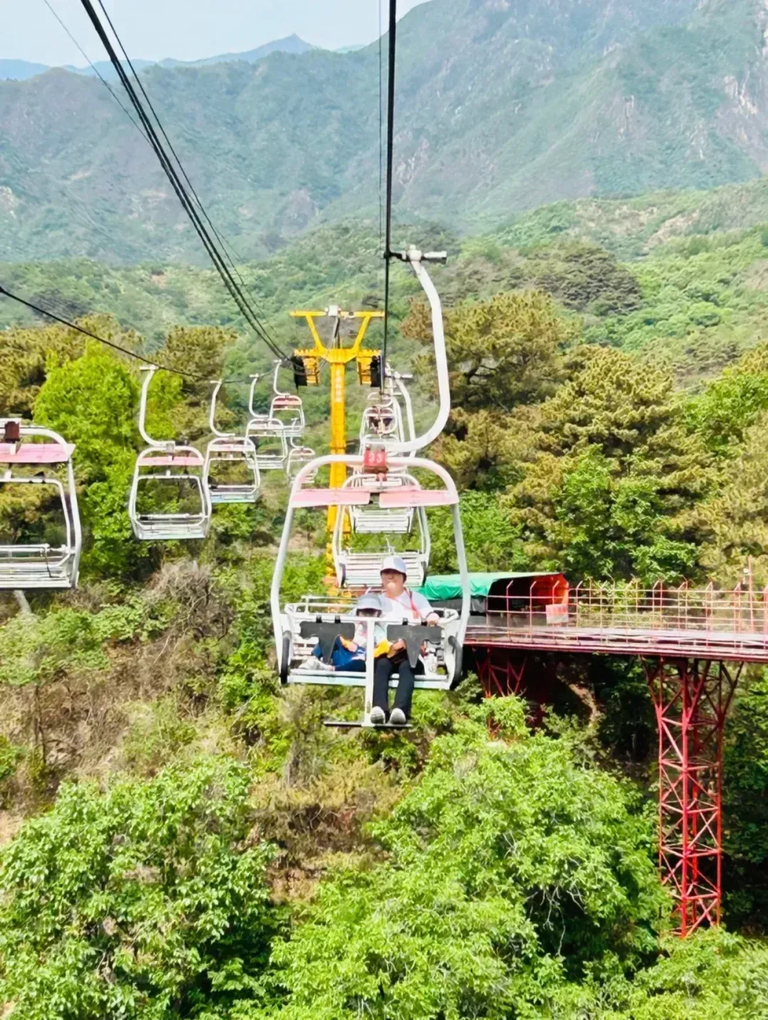 Open chairlift chairs above the Mutianyu Great Wall forest