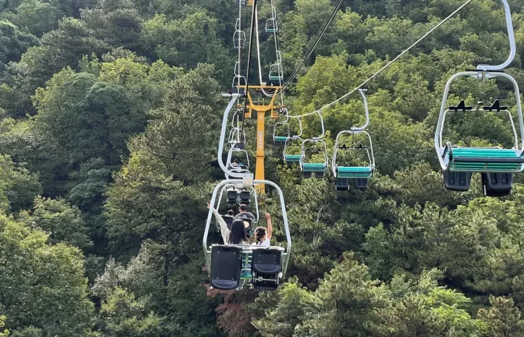 Chairlift above forest at Mutianyu Great Wall for visitors choosing transport up or down the mountain