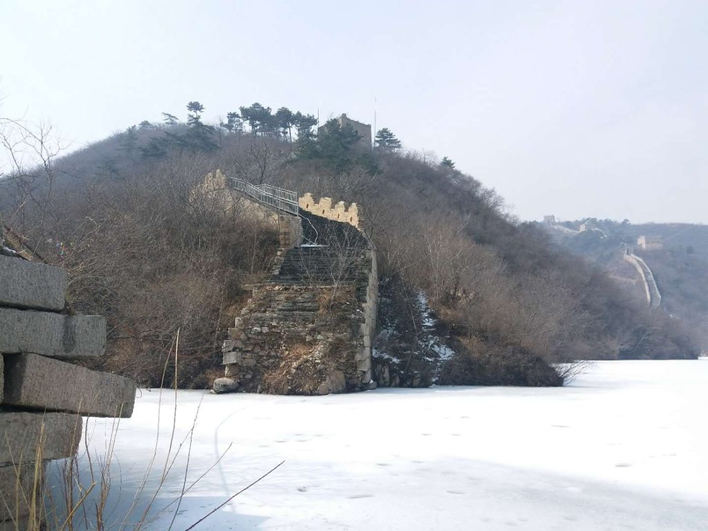 Huanghuacheng Great Wall beside a lake in a quiet mountain landscape