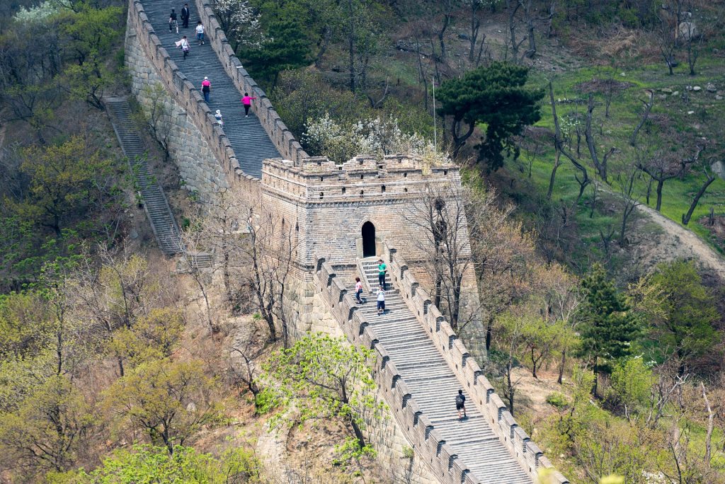 Visitors climbing the steps toward a watchtower at Mutianyu Great Wall
