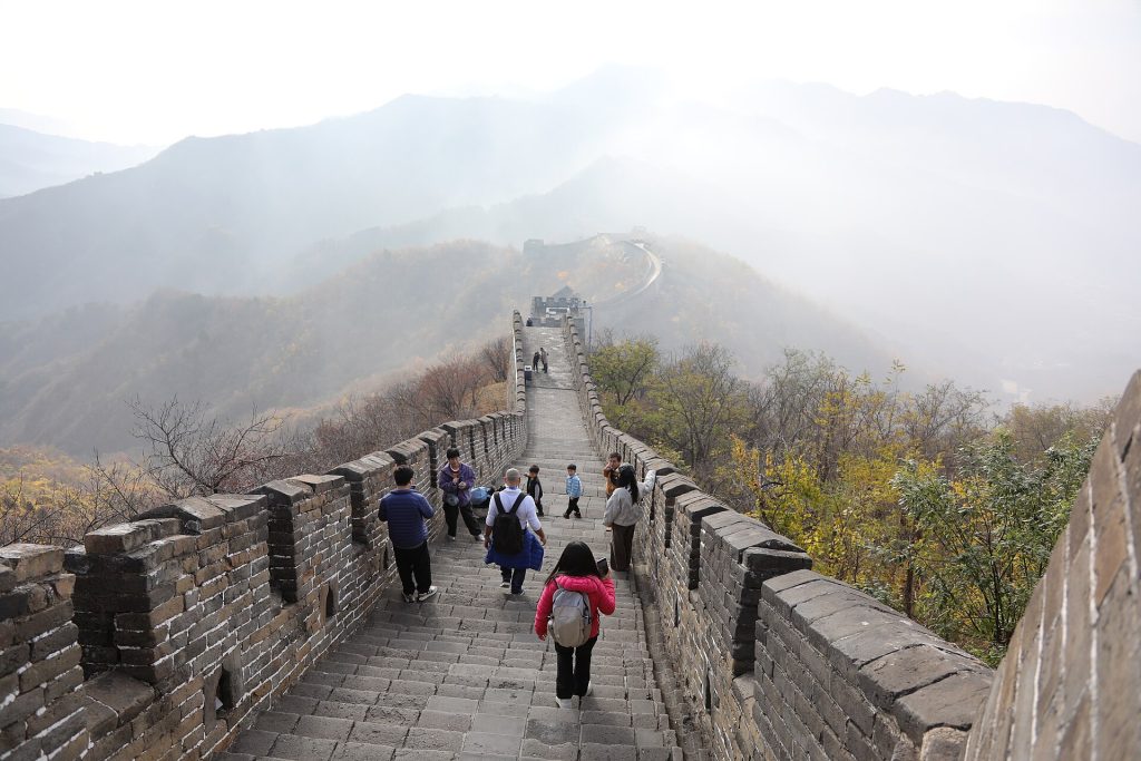 Visitors walking along the Mutianyu Great Wall in autumn light