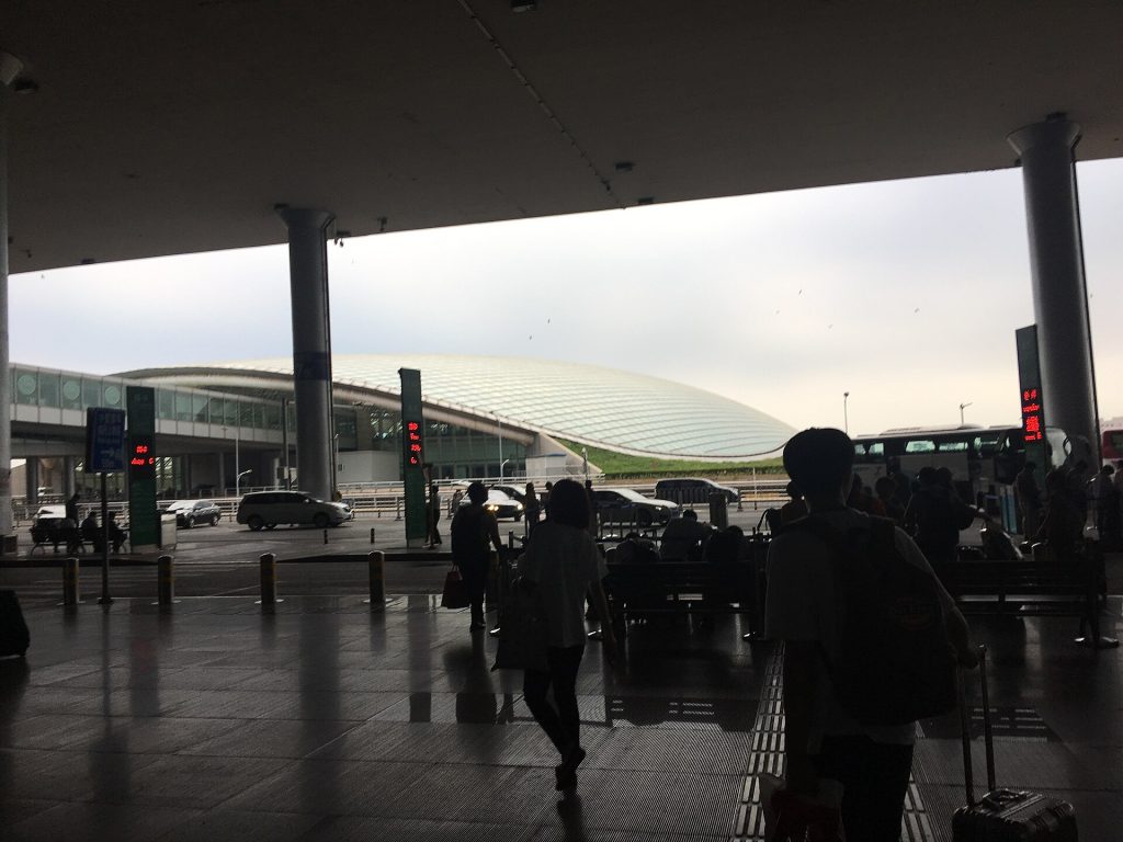 Travelers and cars outside Beijing Capital International Airport