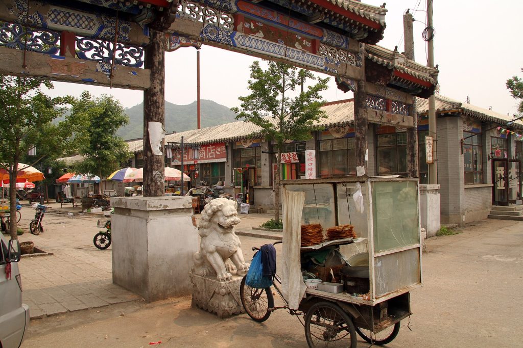 Everyday street scene with a gateway and local buildings in Gubeikou village