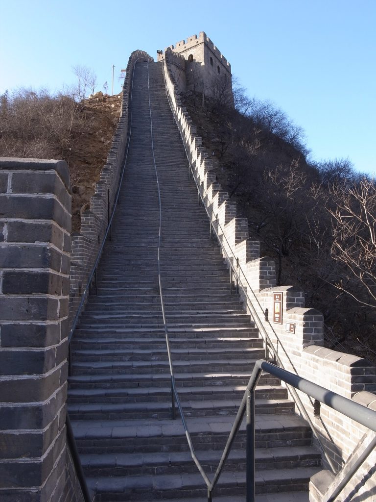 Steep stone steps and handrail rising toward a Shuiguan Great Wall watchtower